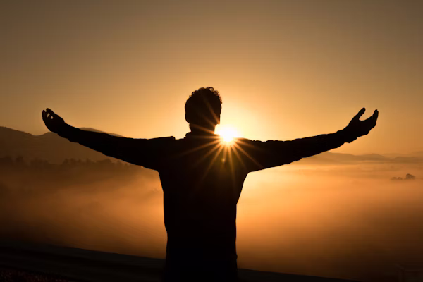 Mindset mastery — person meditating at sunrise